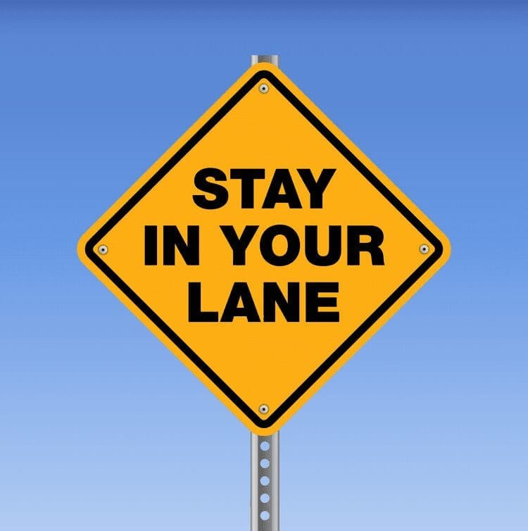 A yellow roadsign says, "stay in your lane."