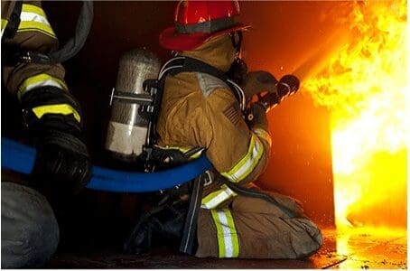 John R Kowalski fights a fire while volunteering as a firefighter.