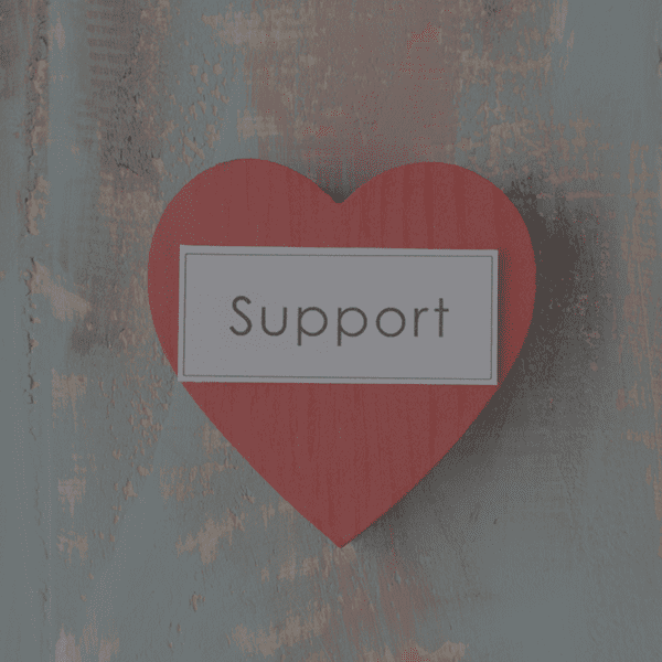 A wooden heart is labeled with a sign reading, "Support."